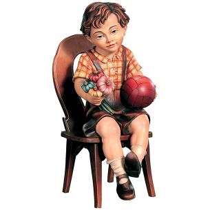 Sitting boy with ball on chair
